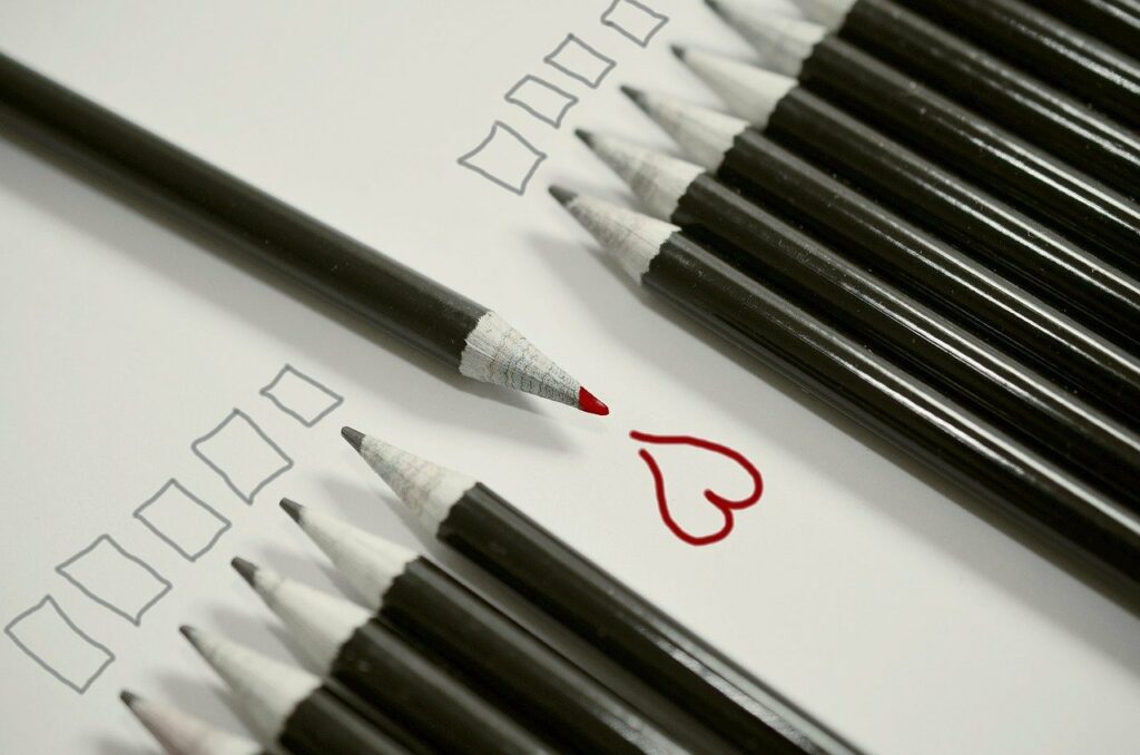 Tužky, kde jedna je opačným směrem a nakreslila červené srdce.
