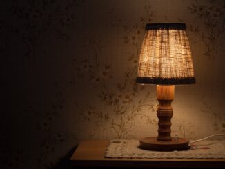 Rozsvícená stará lampička na nočním stolku