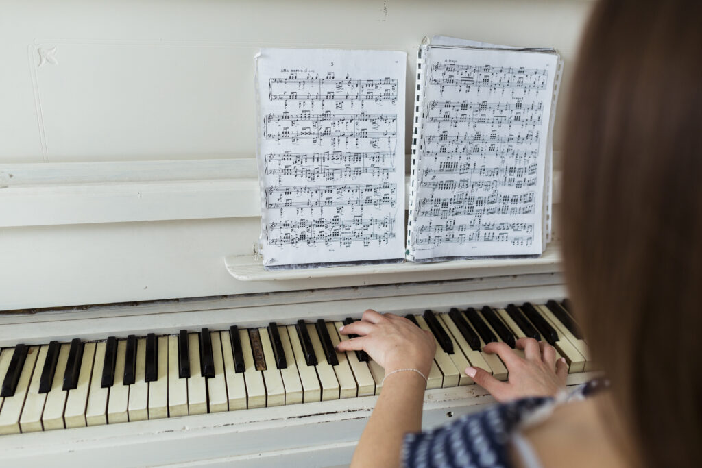 Děvče hraje na klavír podle partitury.