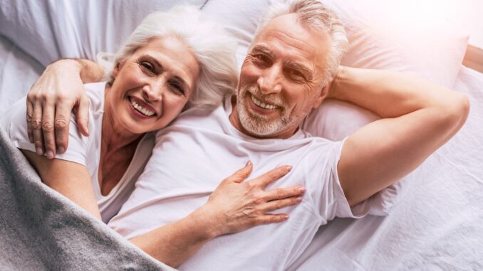 Zamilovaný pár seniorů leží v posteli.