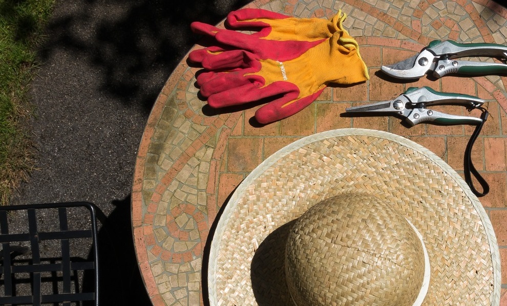 Pracovní rukavice, slamák a zahradní nářadí.