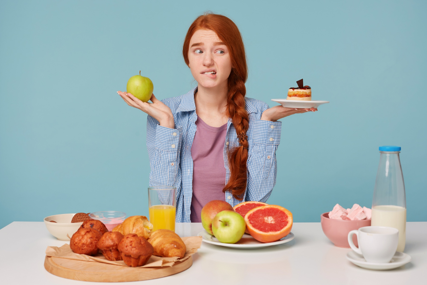 Dívka váhá mezi dietním a sladkým jídlem.