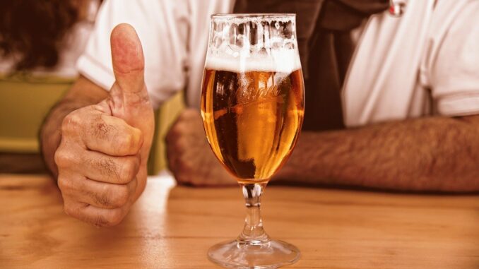 Detail piva, muž ukazuje palec nahoru.