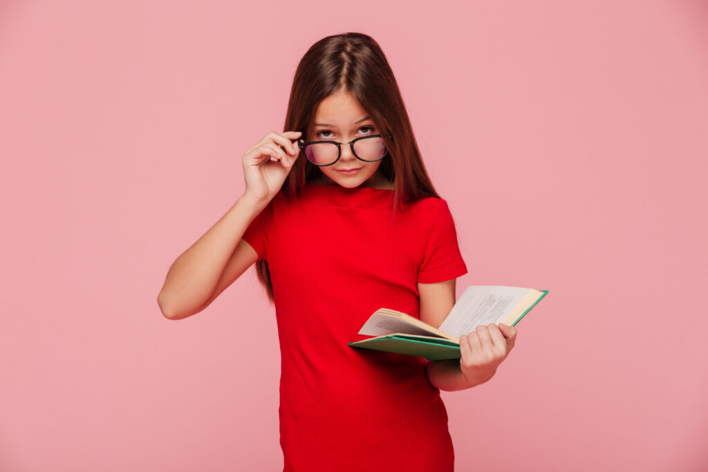 Děvče s brýlemi a knihou v ruce.