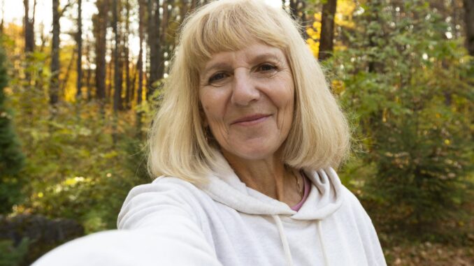 older-woman-taking-selfie-outdoors-nature