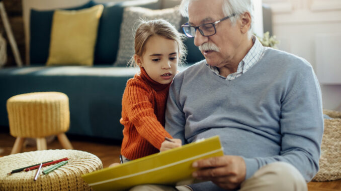 Little girl and her grandfather enjoying in creative time at hom