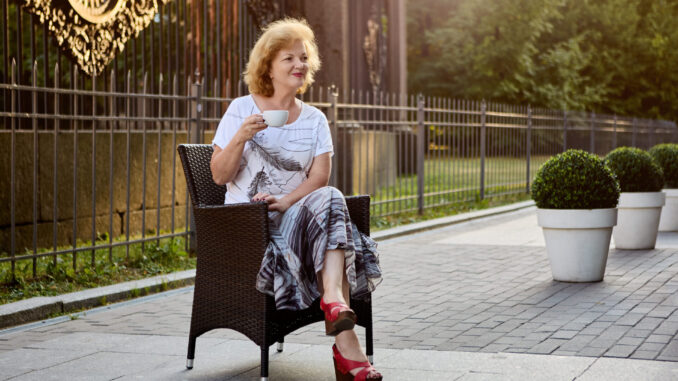 Middle aged woman drinks coffee in St. Petersburg outdoors.