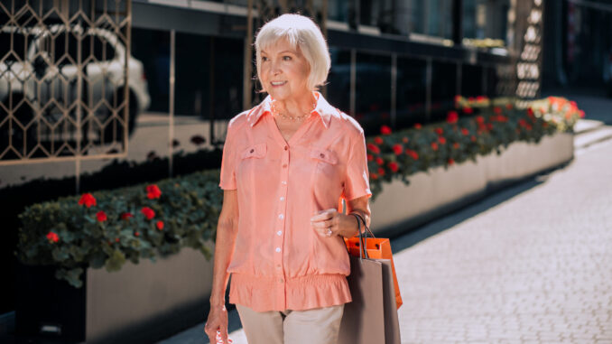 Elderly lady walking with shopping bags stock photo