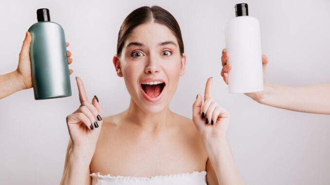 Closeup portrait of joyful girl posing without makeup on white background. Woman chose which shampoo is best to use.