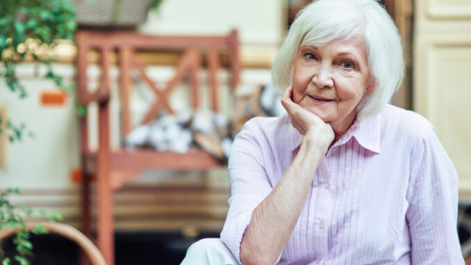 Happy beautiful elderly lady looking at camera outdoors