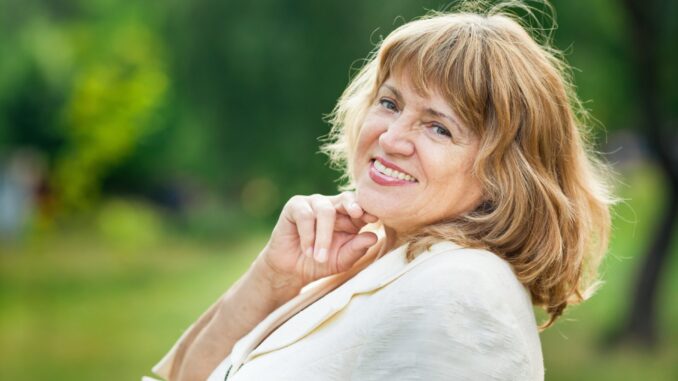portrait-beautiful-senior-blonde-woman-smiling-park