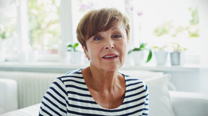 Senior woman sitting on sofa in living room