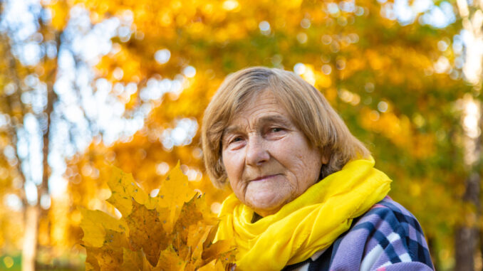 Senior woman in autumn park. Selective focus.